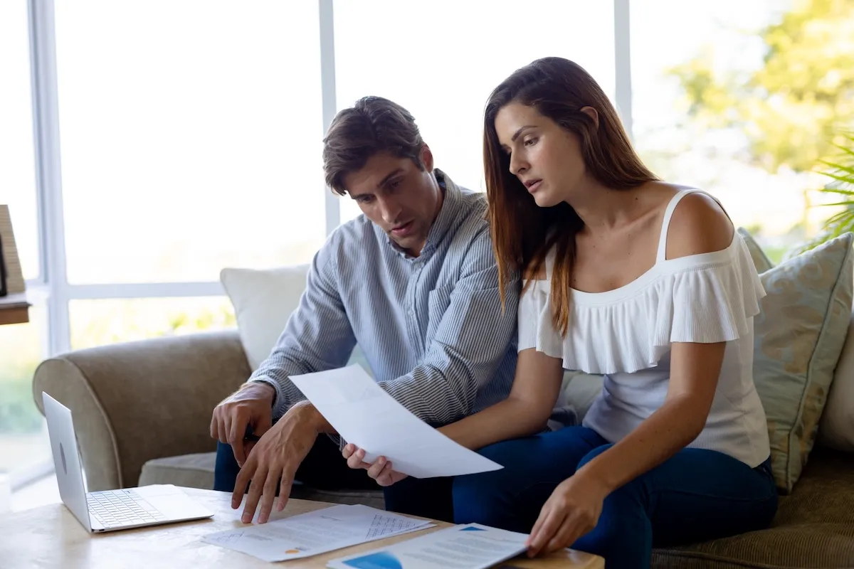 Expat couple reviewing immigration documents in a Parisian apartment