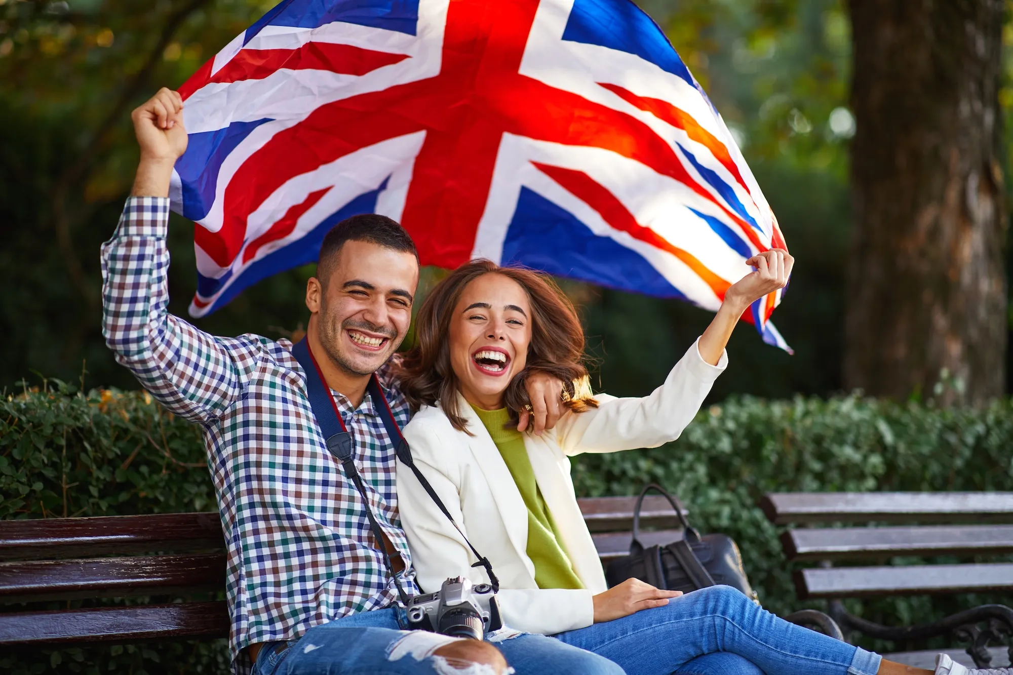 Happy young couple with a UK flag exploring Paris